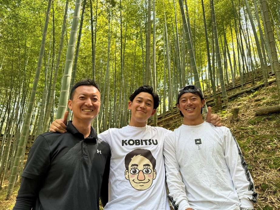 取材を受けた時の写真(竹林を背景に、庄野、レポーター、庄野の知人が並ぶ)